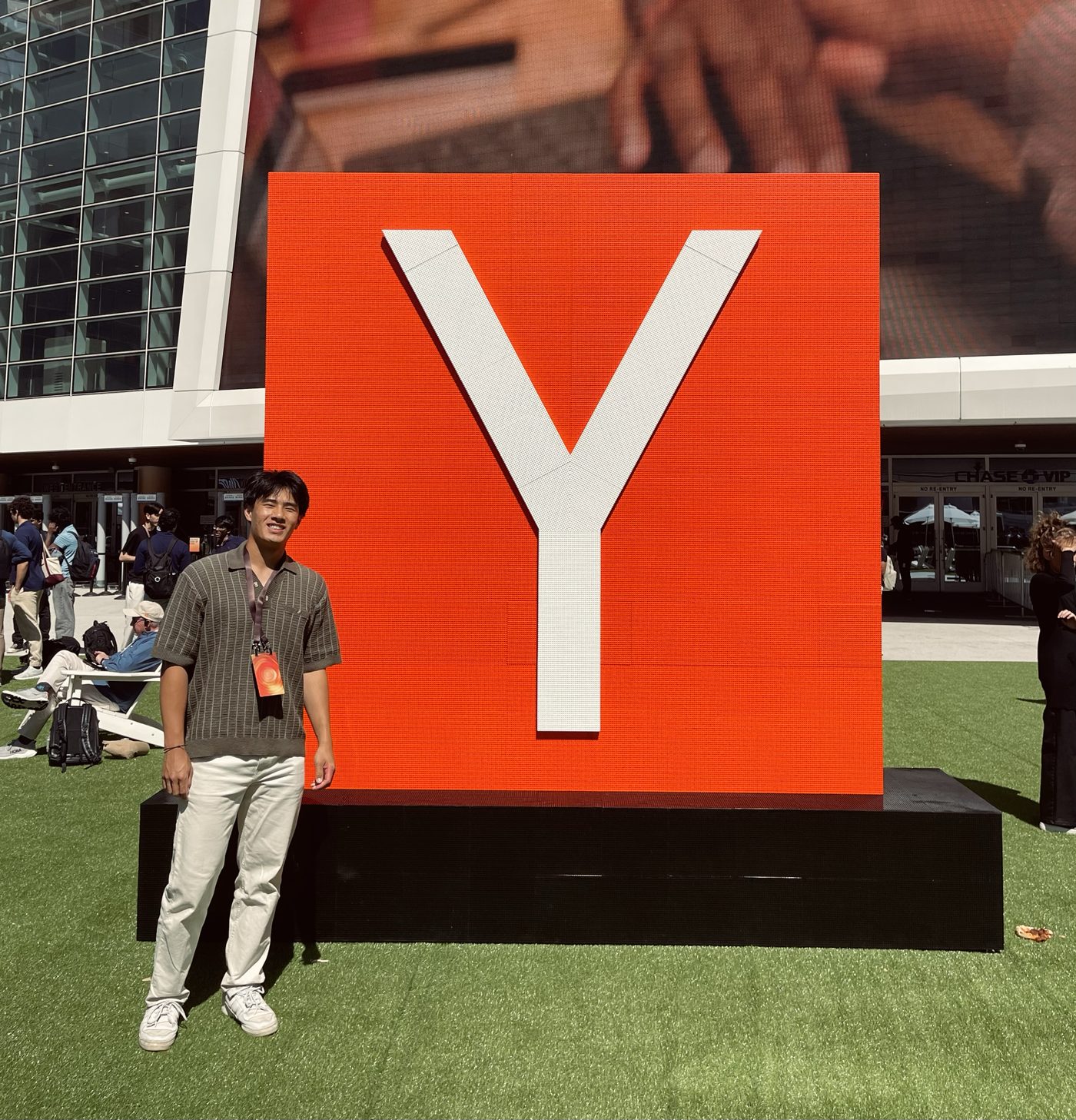 Ethan Fang standing beside a large orange Y Combinator sign in San Francisco